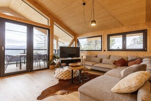 Un salon confortable avec un canapé, un téléviseur et un coin repas comprenant des chaises et une table.
