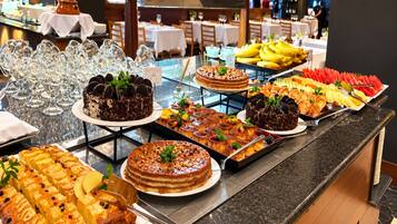 A buffet with various desserts and fruits.