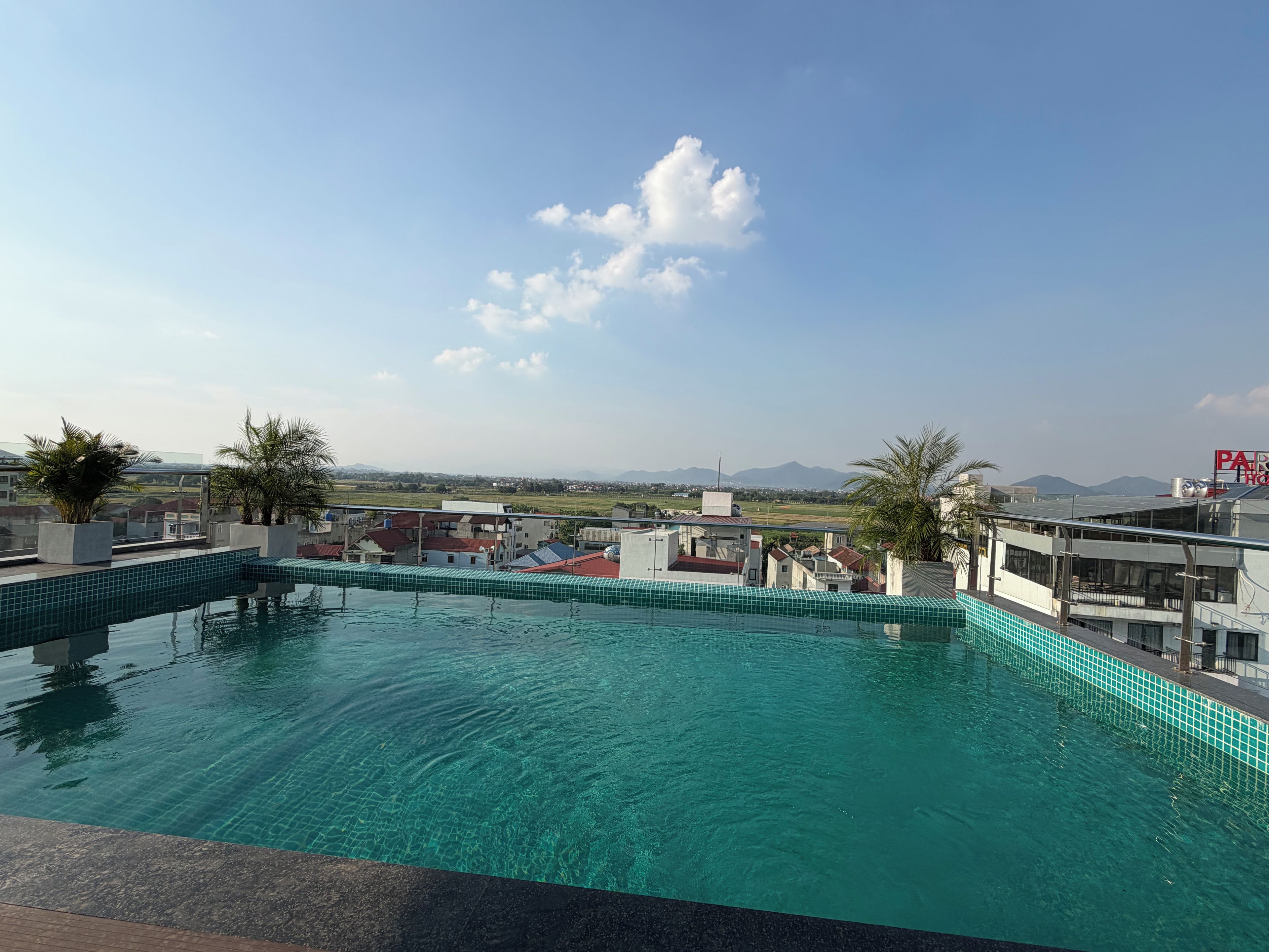 Ein Pool auf dem Dach mit freiem Blick auf die umliegenden Gebäude und ferne Berge.