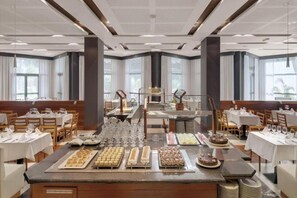 A buffet setup in a hotel dining area with multiple tables and a central serving station.