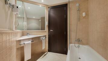 Un baño moderno con bañera, lavamanos y espejo.