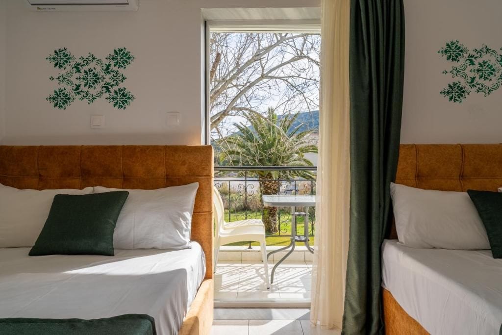 Een hotelkamer met twee bedden, een balkon en decoratieve muurstickers.
