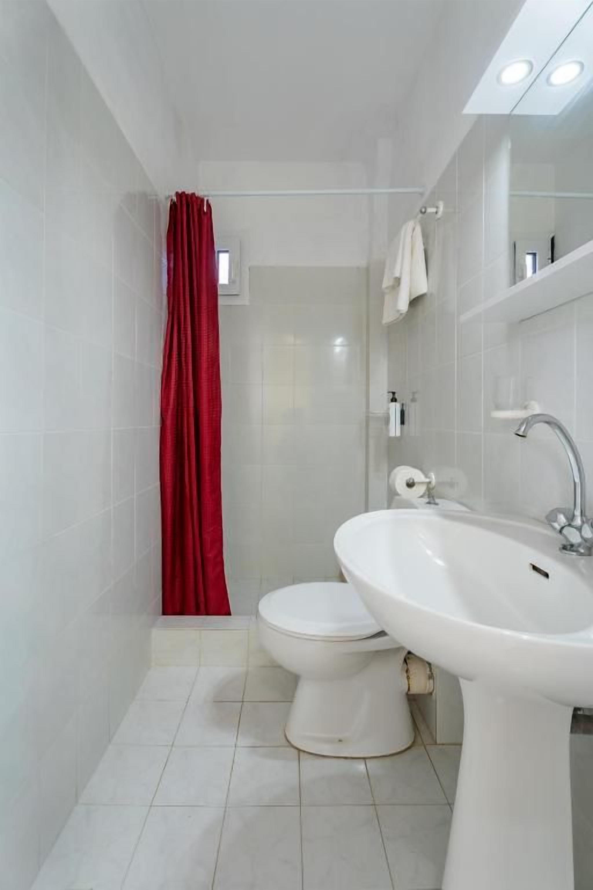 Un baño moderno con inodoro, lavamanos y cortina de ducha.