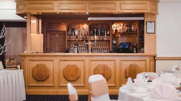 A bar area with wooden paneling and a selection of bottles.