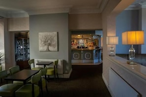Une chambre d’hôtel avec un coin repas, un bar et une vue sur la ville.