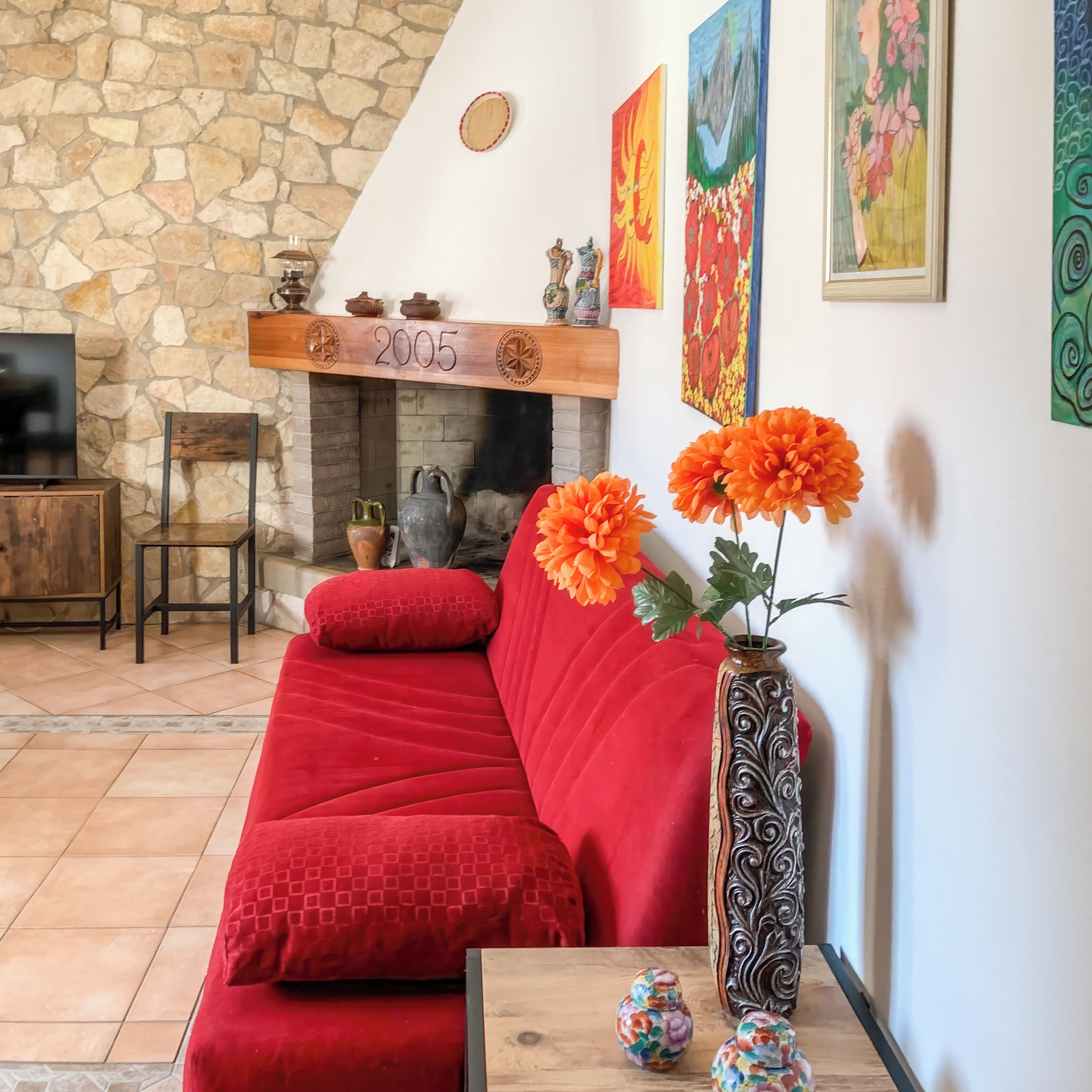 A living room with a red sofa, a fireplace, and decorative items.