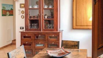 A dining area with a wooden table, chairs, and a cabinet with glass doors.