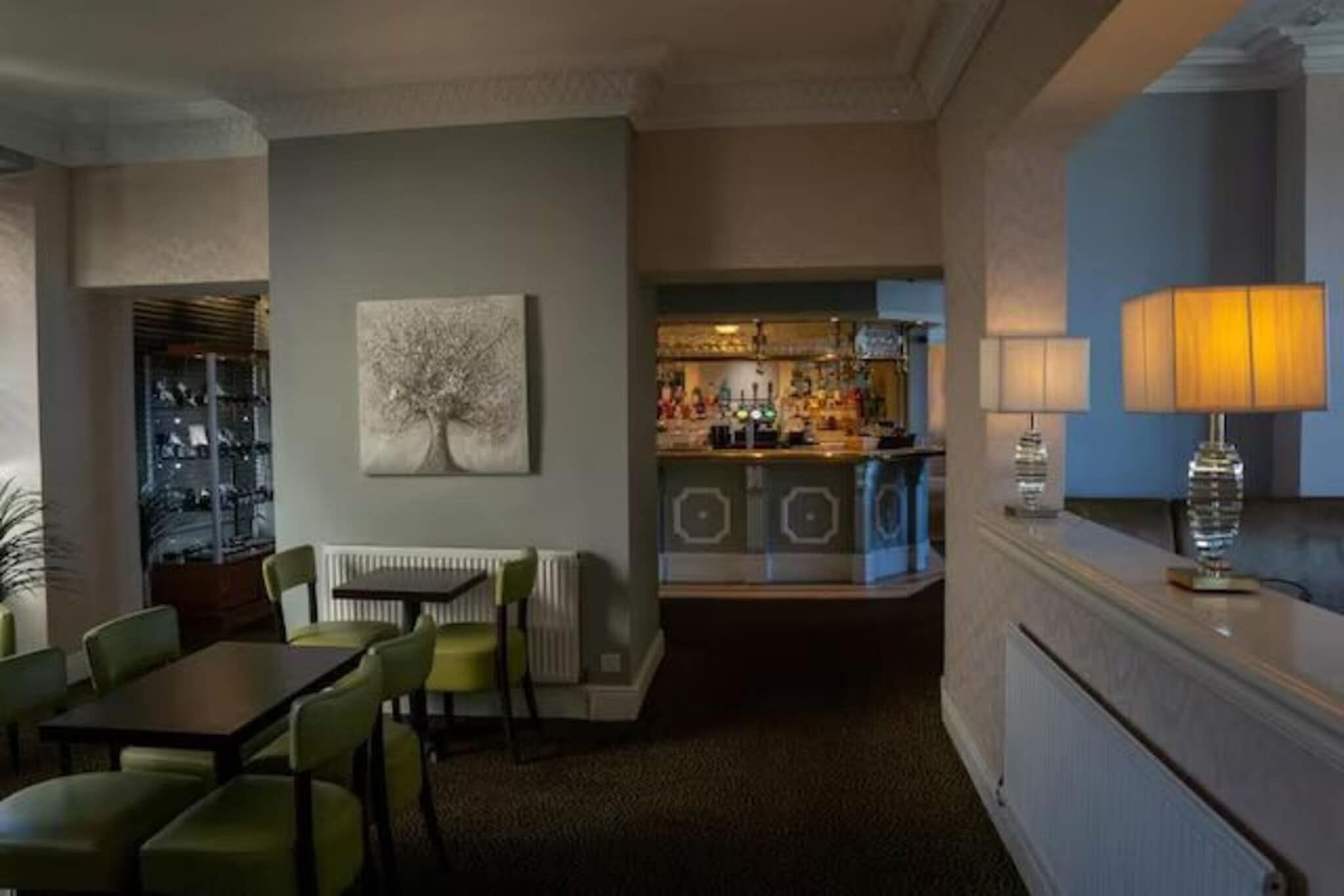 Habitación de hotel con comedor, bar y vistas de la ciudad.