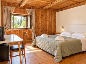 Een kamer met een bed, een bureau en een stoel.