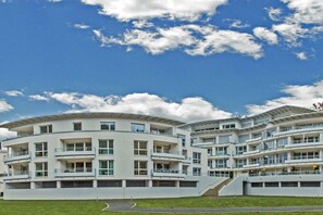 A multi-story residential building with balconies, a curved design, and a clear sky. - Holiday apartment with 1 bedroom (Traben-Trarbach, Deutschland)