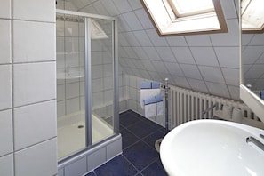 A bathroom with a glass-enclosed shower, a white sink, and a visible towel rack. - Bär's holiday apartment (Eichstetten)