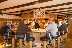 Een bar met houten barstoelen en een centrale bar.
