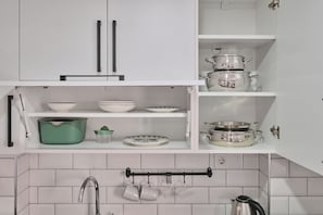 A kitchen with white cabinets, a stainless steel kettle, and various kitchenware. - ÜLKER APARTMENTS (Beyoğlu)