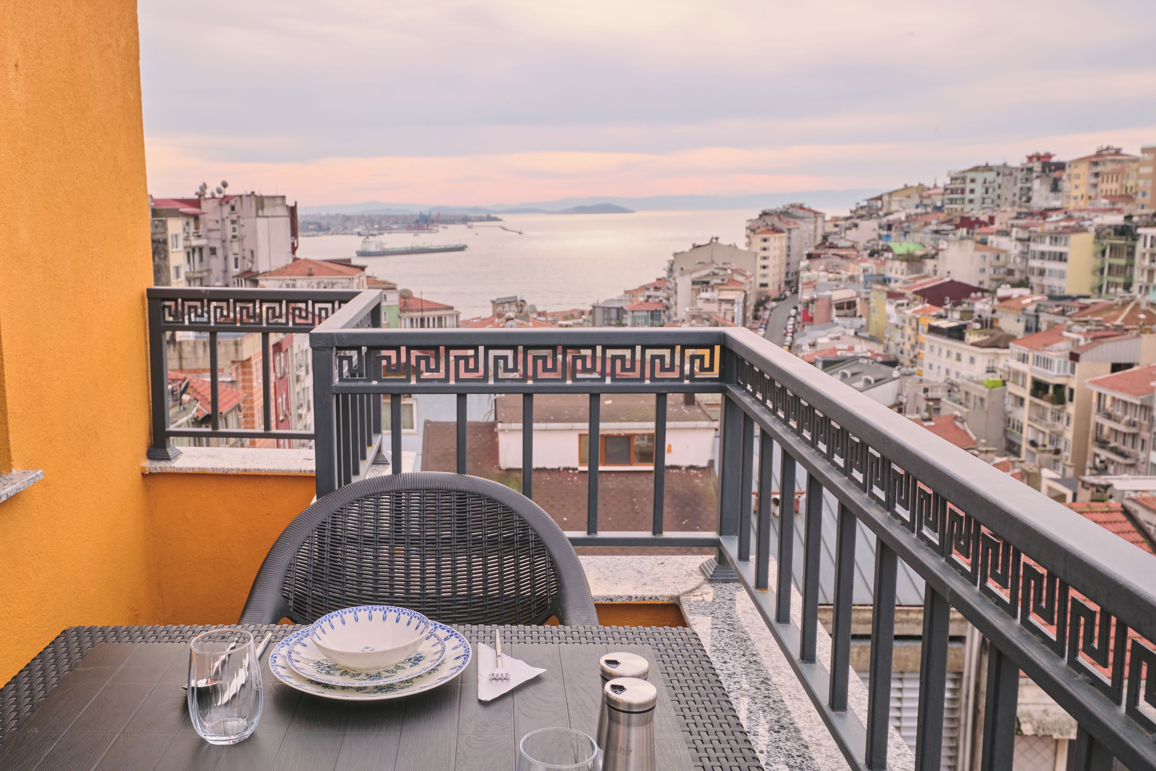 A balcony with a view of a cityscape and a body of water.