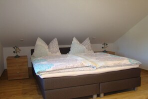 Ein Schlafzimmer mit einem Bett, zwei Nachttischen und einem Beistelltisch.