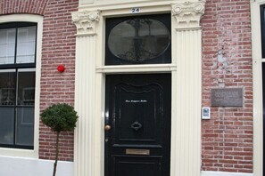 A black door with a brass knocker and a plaque above it. - Luxury holiday apartment 2 Zeeland Domburg (Domburg)