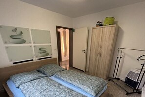 A bedroom with a bed, a wardrobe, a radiator, and wall art. - holiday apartment Brandenburg (Schmallenberg)