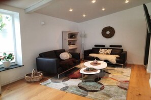 Ein stilvolles Wohnzimmer mit zwei Sofas, einem Couchtisch und einem dekorativen Teppich.