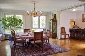A dining room with a chandelier, a large window, and a dining table set for four. - Holiday apartment with 3 bedrooms (Nassau)