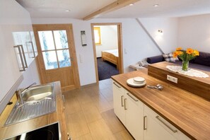 Una cocina moderna con encimera de madera, un fregadero y un comedor con mesa y sillas.