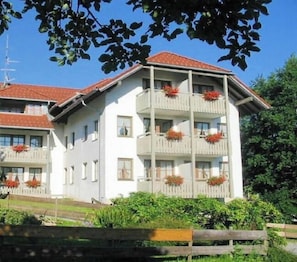 A multi-story building with balconies, a white facade, and a red roof. - Holiday apartment with 1 bedroom (Bad Hindelang)