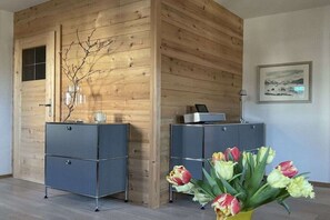 A room with wooden panel walls, a desk with a lamp, and a framed picture on the wall. - Holiday apartment with 1 bedroom (Fischbachau)