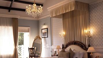 A bedroom with a large bed, a chandelier, and a view of the outdoors.