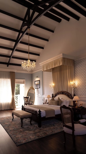 A bedroom with a large bed, a chandelier, and a view of the outdoors. - KELSO (Ooty)