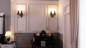 A room with a black console table, a lamp, a framed picture, and wall sconces.