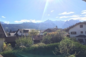 A residential area with houses, a mountain range in the background, and a clear sky. - Holiday home with 4 bedrooms (Garmisch-Partenkirchen)