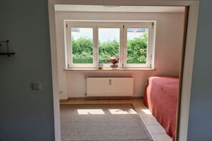 A bedroom with a window, radiator, and a bed. - Holiday apartment with 2 bedrooms (Garmisch-Partenkirchen)