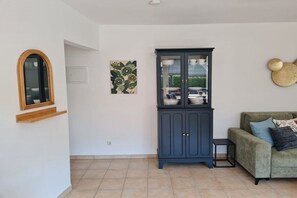A living room with a dark blue cabinet, a green sofa, and a small side table. - Holiday apartment with 2 bedrooms (Garmisch-Partenkirchen)