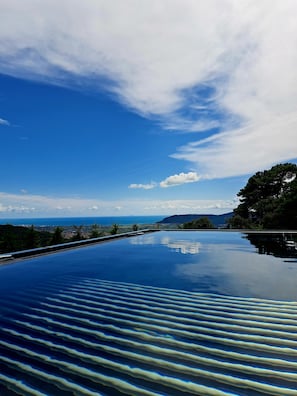A clear view of a swimming pool with a distant landscape, including a body of water and mountains. - Villa Vinomare in Lunigiana. Infinity hot tub with sea view (Toscana)