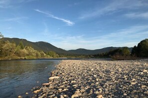 A riverbank with a rocky shore and a backdrop of mountains. - Holiday apartment with 1 bedroom (Lenggries)