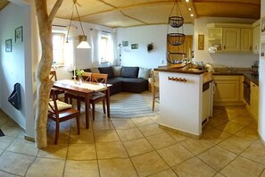 A cozy living area with a dining table, sofa, and kitchen. - Holzner "Holidays like on a farm" (Inzell)