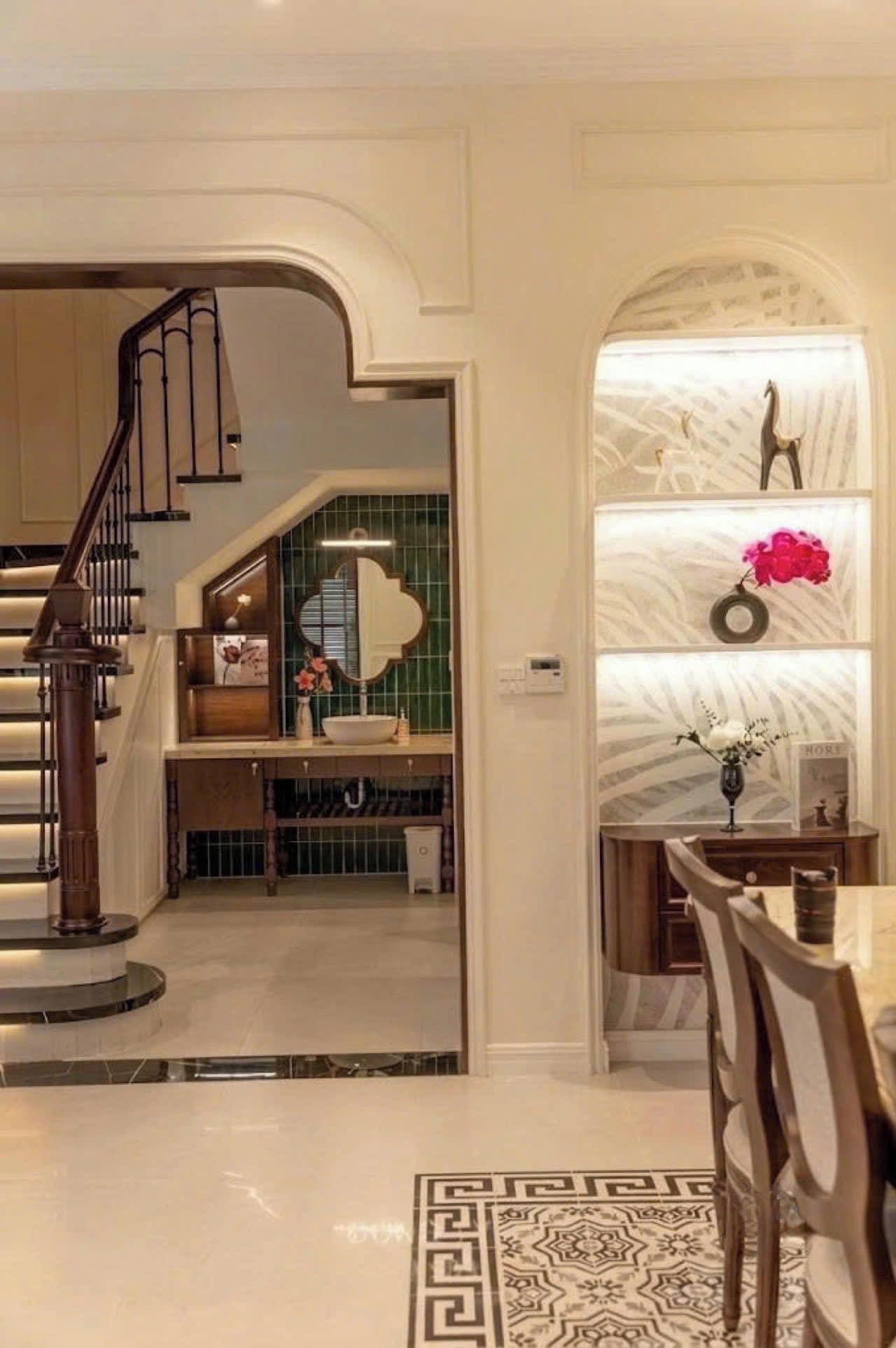 A modern interior with a staircase, a kitchen area, and a dining space.