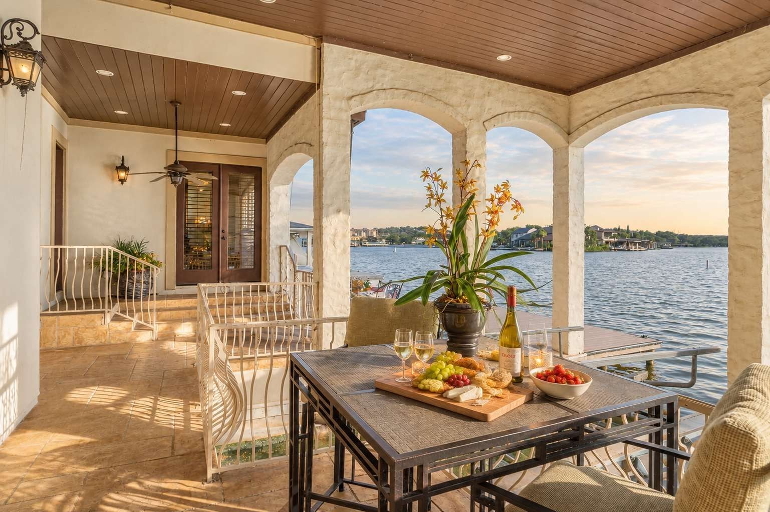 Una terraza con una mesa lista para comer, con vista a un cuerpo de agua.