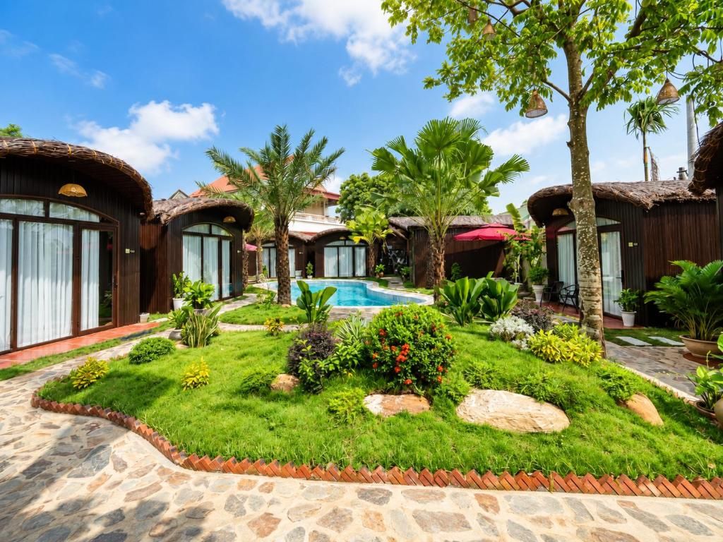 A resort with thatched-roof cottages, a swimming pool, and a well-maintained garden.