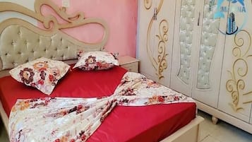 Un dormitorio con cama, mesita de noche y armario.