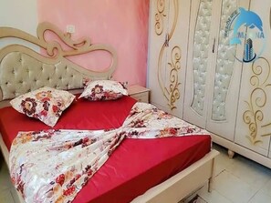 Ein Schlafzimmer mit Bett, Nachttisch und Kleiderschrank.