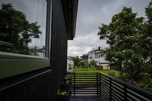 Un balcón con vistas a una zona residencial, con casas y árboles.