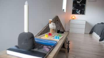 Une chambre à coucher comprenant un lit, une table de chevet, une lampe et une étagère fixée au mur.