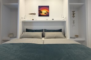 A bed with a headboard, a wall-mounted shelf with a painting, and a small table with a lamp. - Villa 'Casa Celestella' near the beach with private pool, sea & mountain views (Benissa)