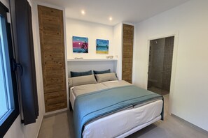 Een slaapkamer met een bed, houten lambrisering, een douche en twee schilderijen die aan de muur hangen.