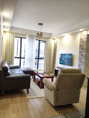 A modern living room with a sofa set, a coffee table, and a television. - Inaya Siaya Park (Kangundo)