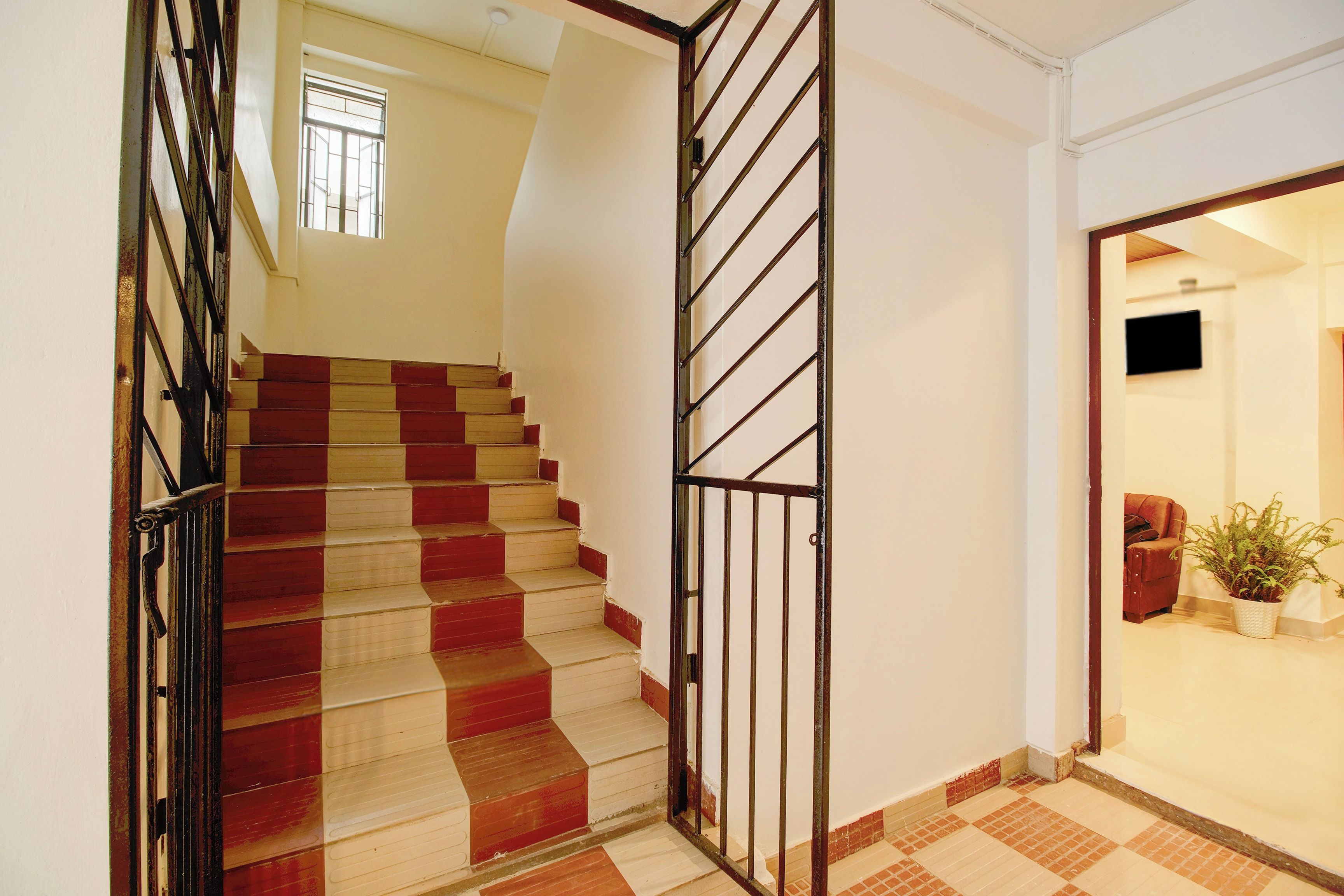 A staircase with alternating red and beige steps leading to a landing.