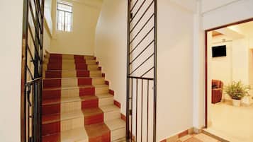 Una escalera con escalones que alternan rojo y beige, que conducen a una plataforma.