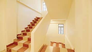 A staircase with alternating red and beige steps leading to a landing.