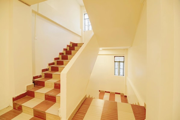 A staircase with alternating red and beige steps leading to a landing.