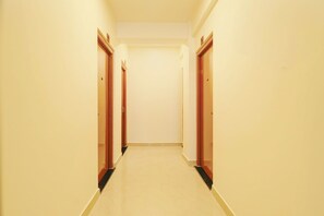 A corridor with doors on both sides, leading to a plain wall at the end.